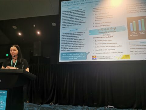 OT CPD Conference Presenter at lectern with slide on the screen